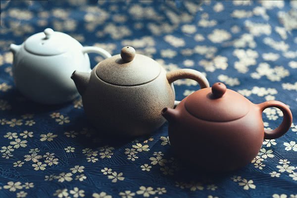 The pottery teapots have a primitive appearance