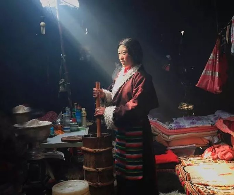 A folk is preparing the yak butter with a Chandong