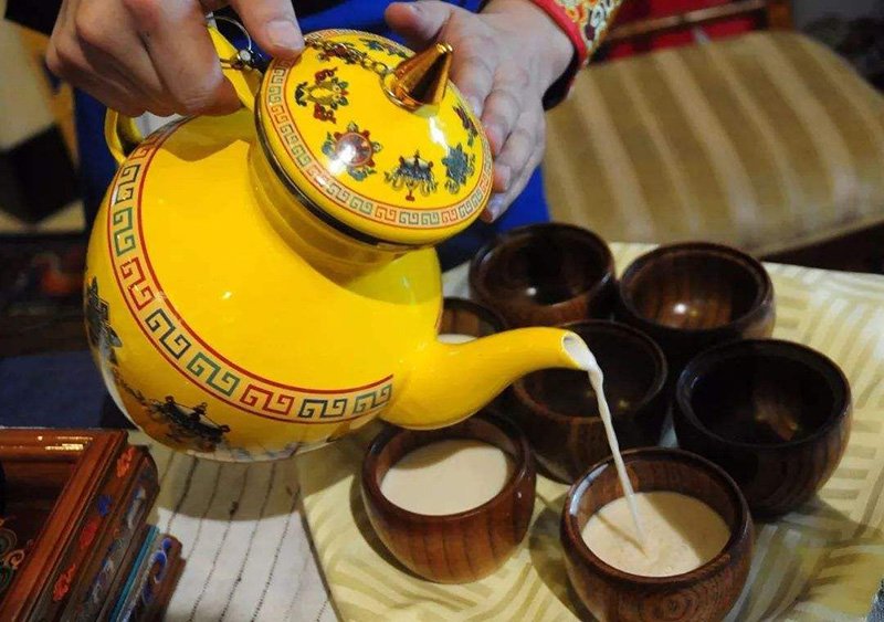 Host serving the butter tea to guest