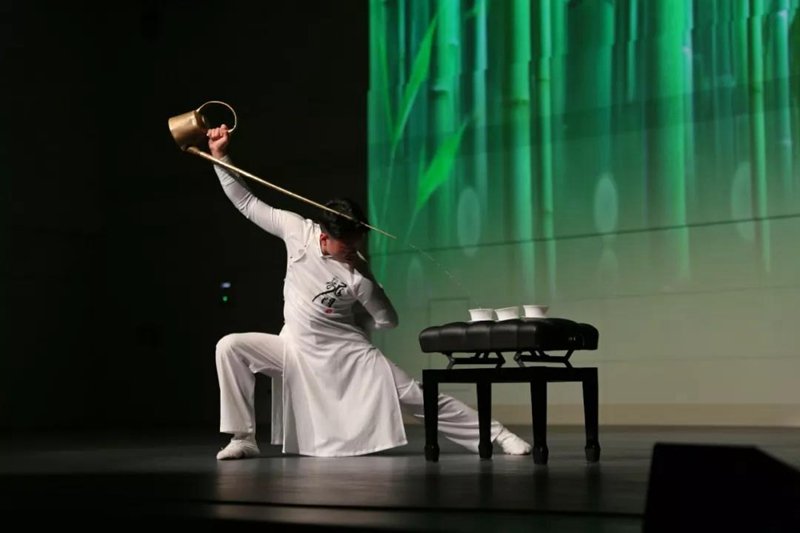 A Dr. Tea is playing a show using a long spout copper teapot