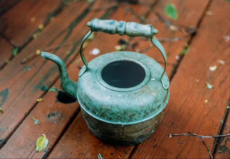 This copper teapot is badly corroded and covered with verdigris